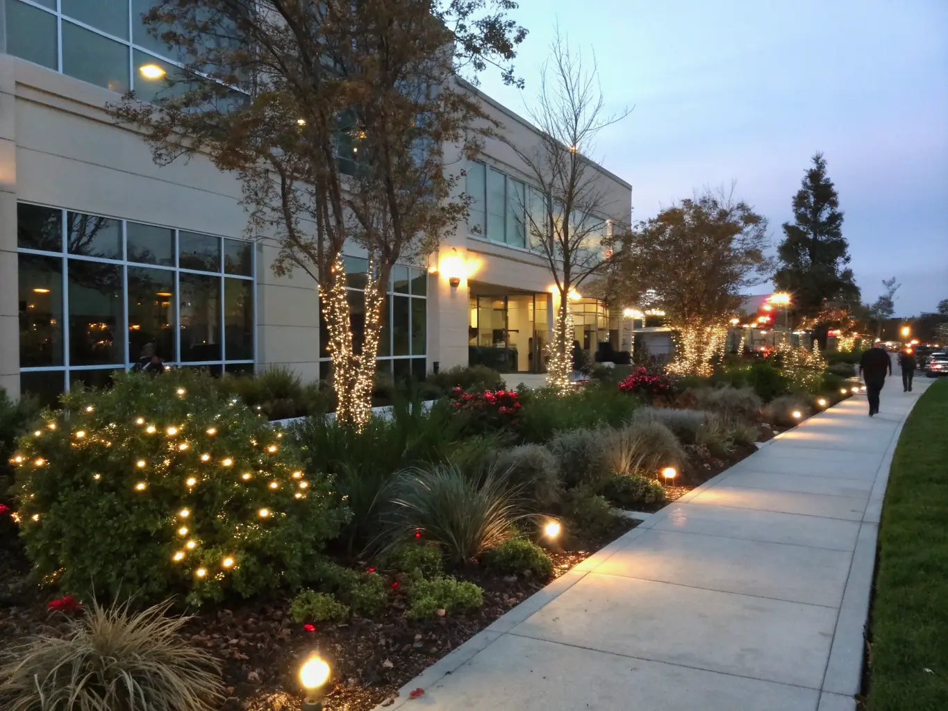 A modern commercial property with landscaped walkways, trees, and decorative plants, showcasing commercial landscaping services by Backyard Boys Landscaping.
